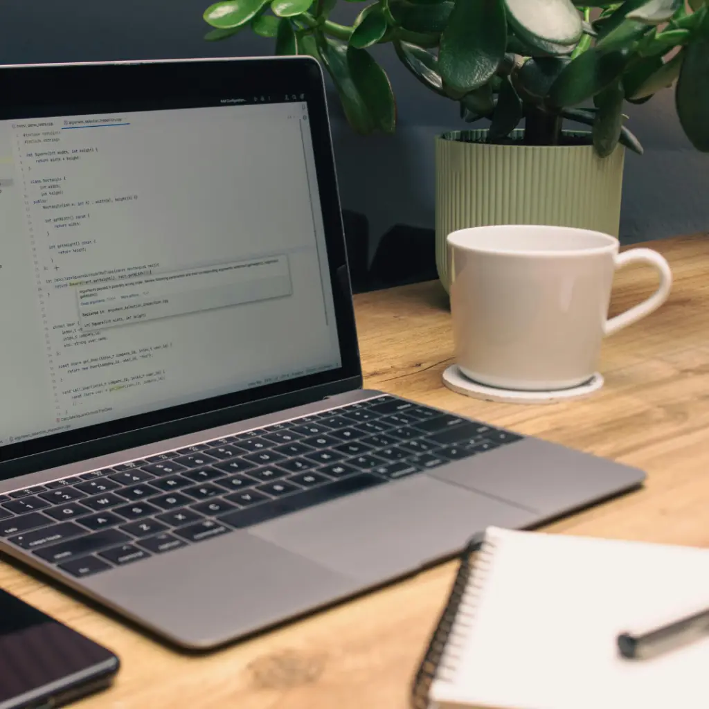 Clean home office setup with laptop and coffee representing organized marketing support